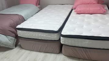 Una habitación con dos camas, cada una con colchón y almohadas.