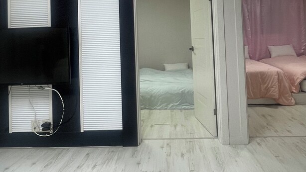 Een kamer met een bed, een televisie en een deur naar een andere kamer.