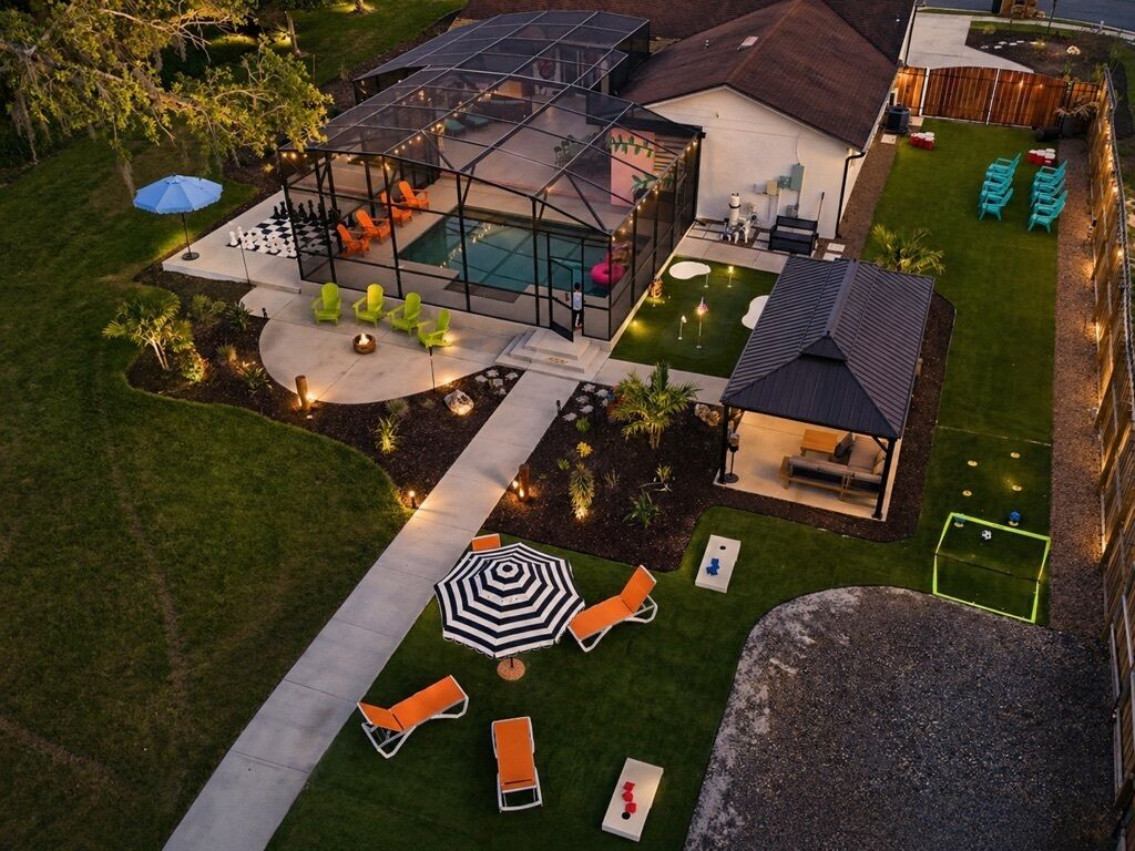 A modern house with a swimming pool, outdoor seating, and a tennis court.