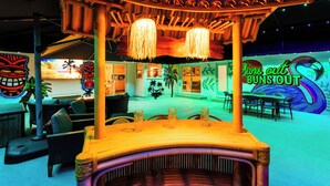 A tiki bar with a wooden canopy, hanging lamps, and a neon sign. - The Tiki Palm- Screened Pool, Mini Golf, Arcade & Creekside Fun (Longwood)