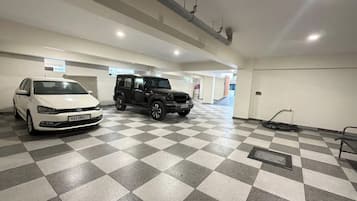Un parcheggio multipiano con due auto parcheggiate, un pavimento a scacchi e un'uscita ben visibile.