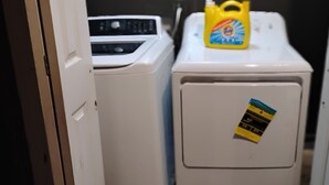 A laundry area with two washing machines and a detergent bottle. - Comfortable and unique 5-bedroom apartment with AC in Fort Valley (Fort Valley)