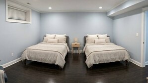 Ein Zimmer mit zwei Betten, einem Nachttisch und einem Fenster mit Jalousien.