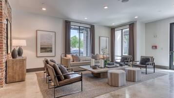 A spacious living room with a sofa, chairs, a coffee table, and a fireplace.