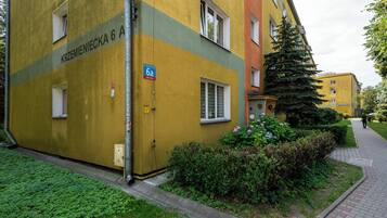 A yellow building with a sign reading 'Krzemieniecka 6a' and a '6a' parking sign.