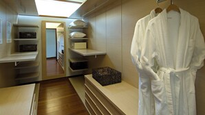 Ein begehbarer Kleiderschrank mit Regalen, einem Kleiderbügel und einem Korb.