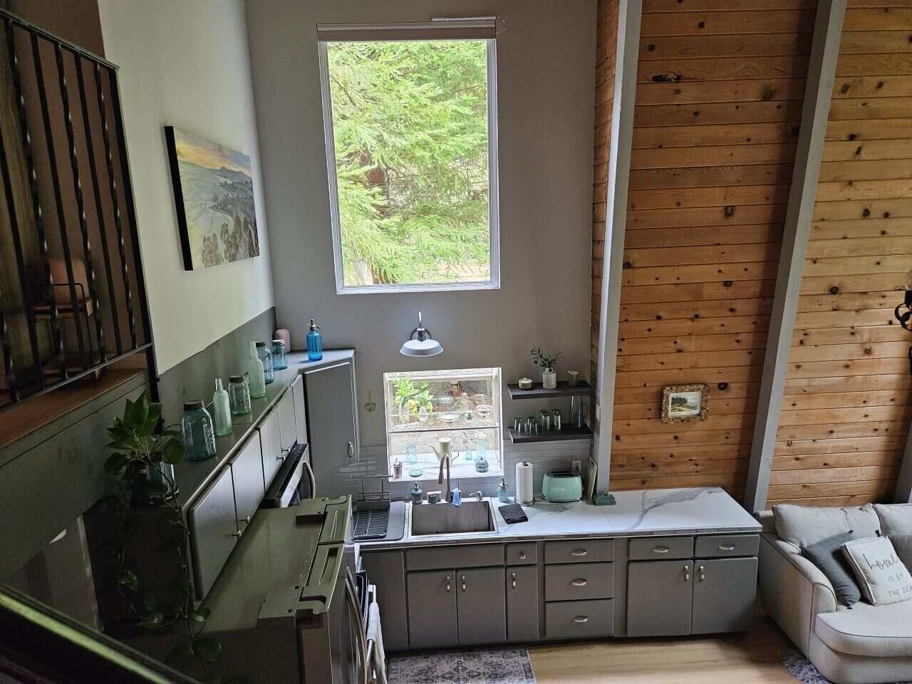 Eine kleine Küche mit Fenster, Spüle und einem eingebauten Backofen.