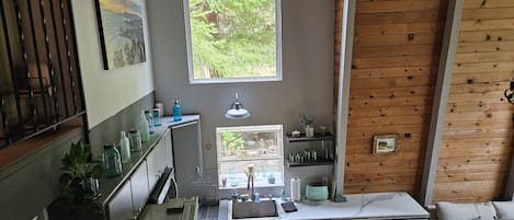 Eine kleine Küche mit Fenster, Spüle und einem eingebauten Backofen.