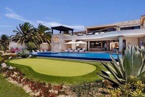 A modern house with a swimming pool, outdoor seating, and a well-maintained garden. - Breathtaking Cabo Villa | Epic Golf & Ocean Views (Cabo San Lucas)
