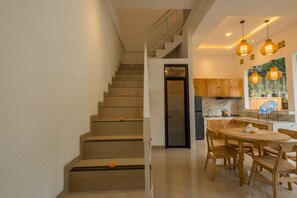 Una cocina moderna con comedor, una escalera y vistas al exterior.