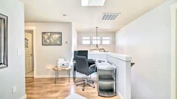 A modern office space with a desk, chair, and shelving unit.
