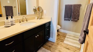 Une salle de bain avec deux vasques, un meuble-lavabo, un miroir et une douche à l’italienne.