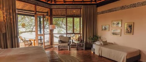 Una habitación con cama, escritorio, silla y vista al exterior.