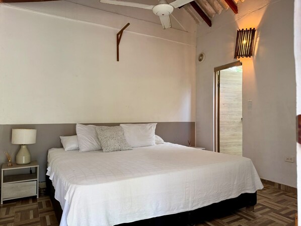 A bedroom with a bed, nightstand, lamp, and a ceiling fan. - Raices del rosario  (Rosario Islands)