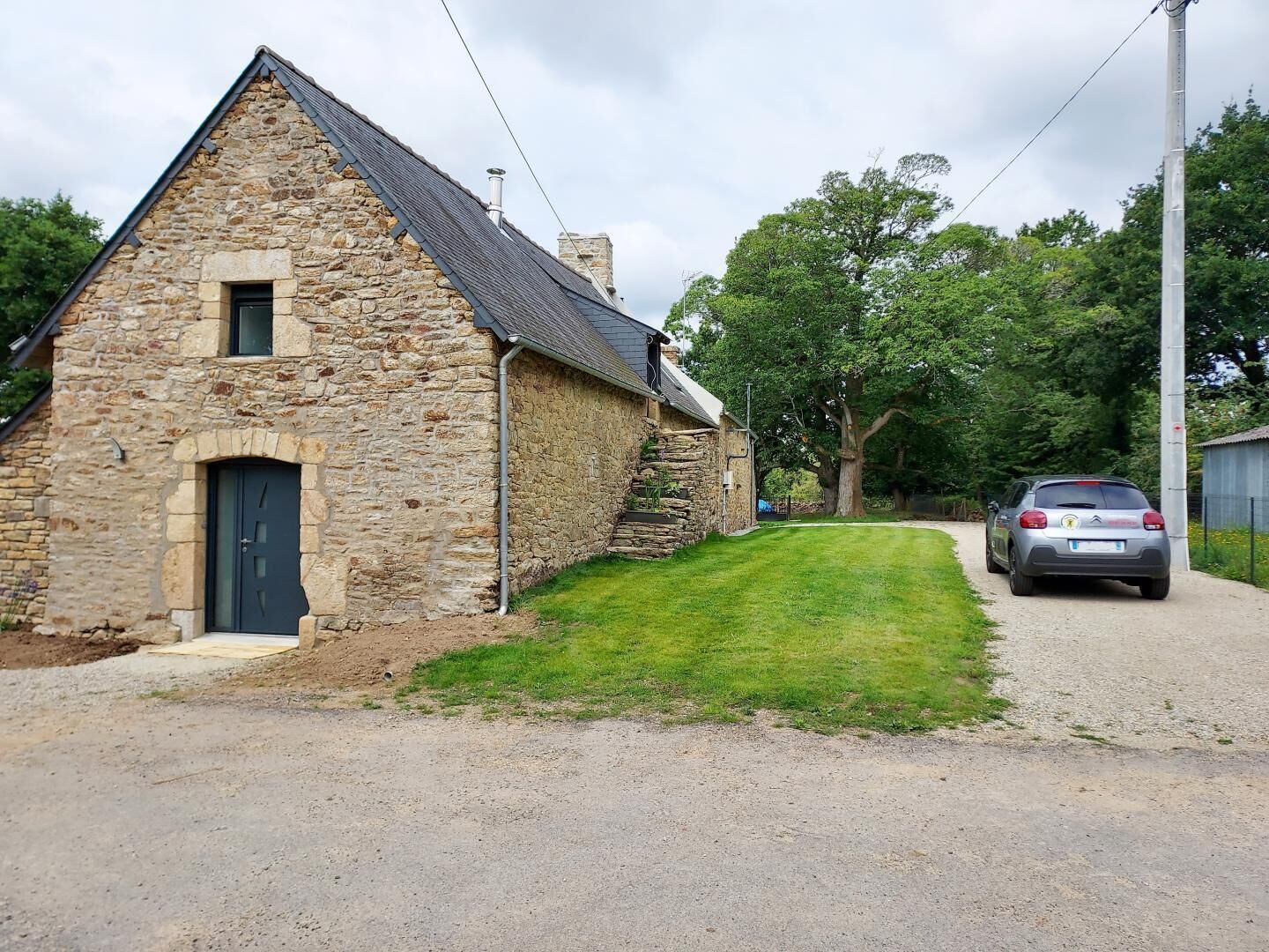 A stone building with a sloped roof, a door, and a small window.