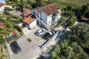 A two-story building with a tiled roof, a covered parking area, and a staircase leading to the upper floor. - Studio Nik Garden & Jacuzzi near Portoroz, Portorož - Sečovlje, Slovenia (Portorož - Sečovlje)
