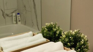 Una scatola di legno con asciugamani piegati su un ripiano del bagno.