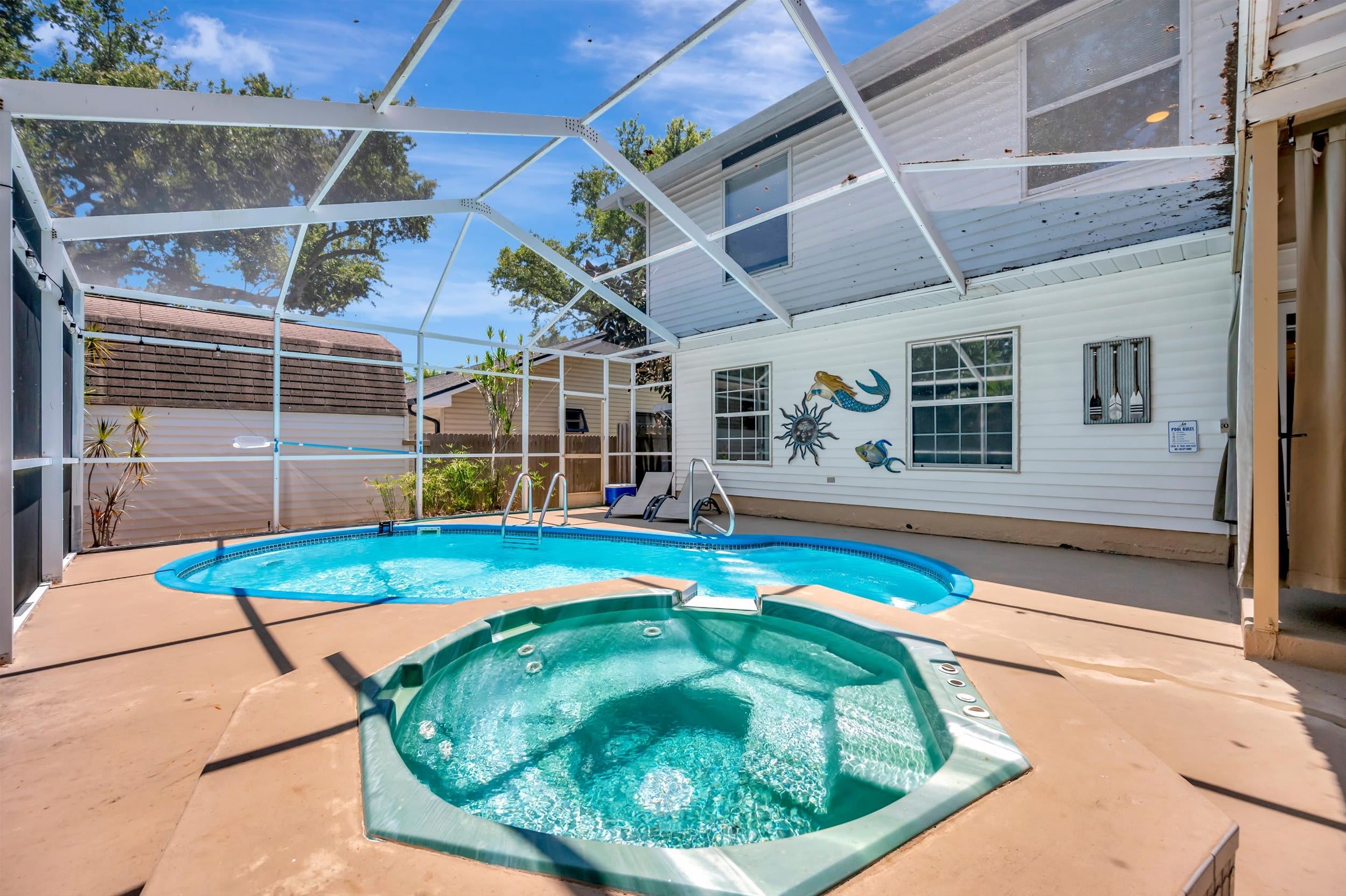 Your private oasis awaits under a bright Florida sky—dive into the sparkling pool or unwind in the bubbling hot tub, all beneath a screened enclosure that keeps the sunshine in and the bugs out.