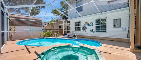 Your private oasis awaits under a bright Florida sky—dive into the sparkling pool or unwind in the bubbling hot tub, all beneath a screened enclosure that keeps the sunshine in and the bugs out.
