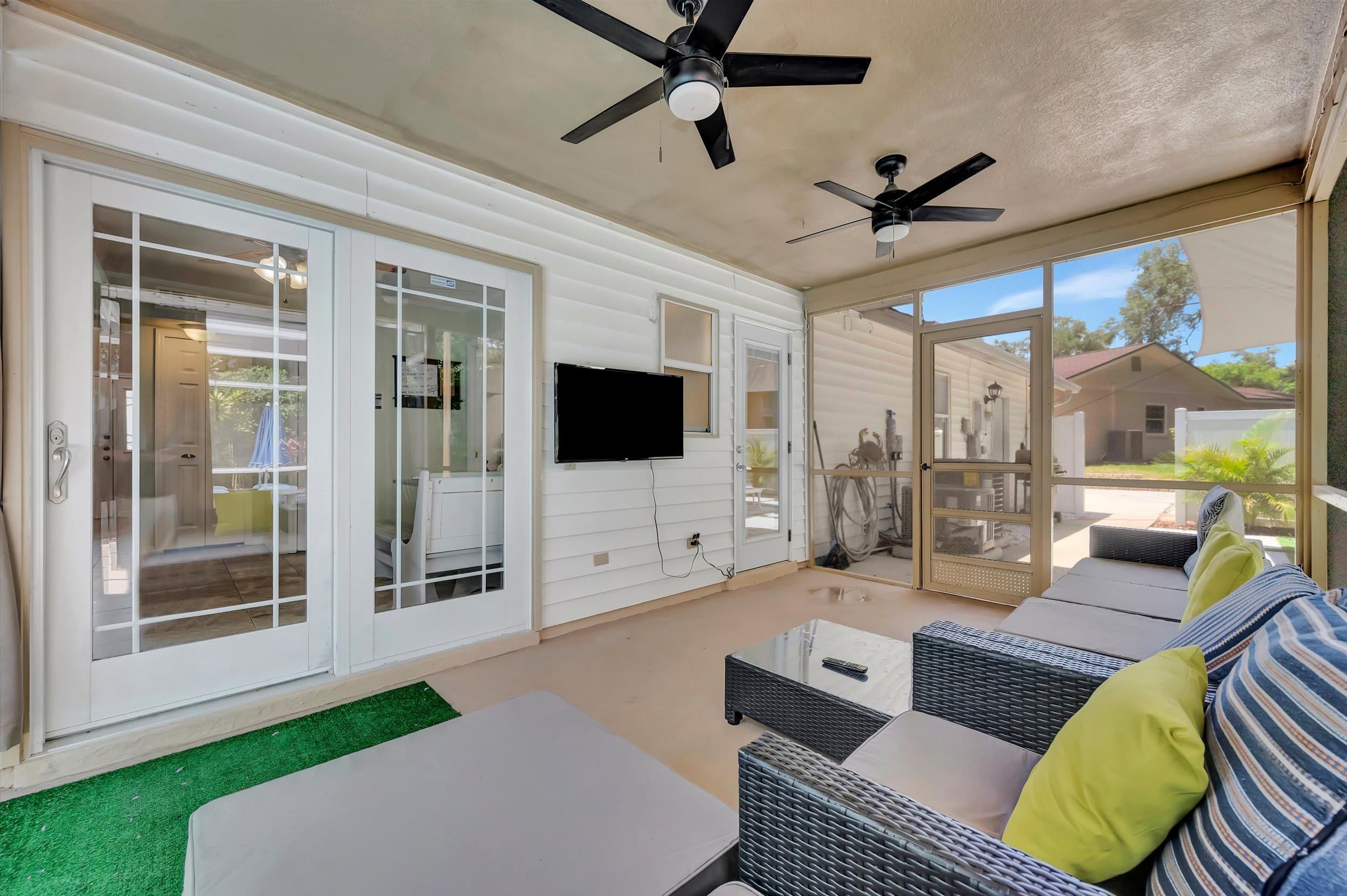 Relax in your private screened patio with ceiling fans keeping you cool while you unwind on comfortable outdoor seating—perfect for morning coffee or evening gatherings.