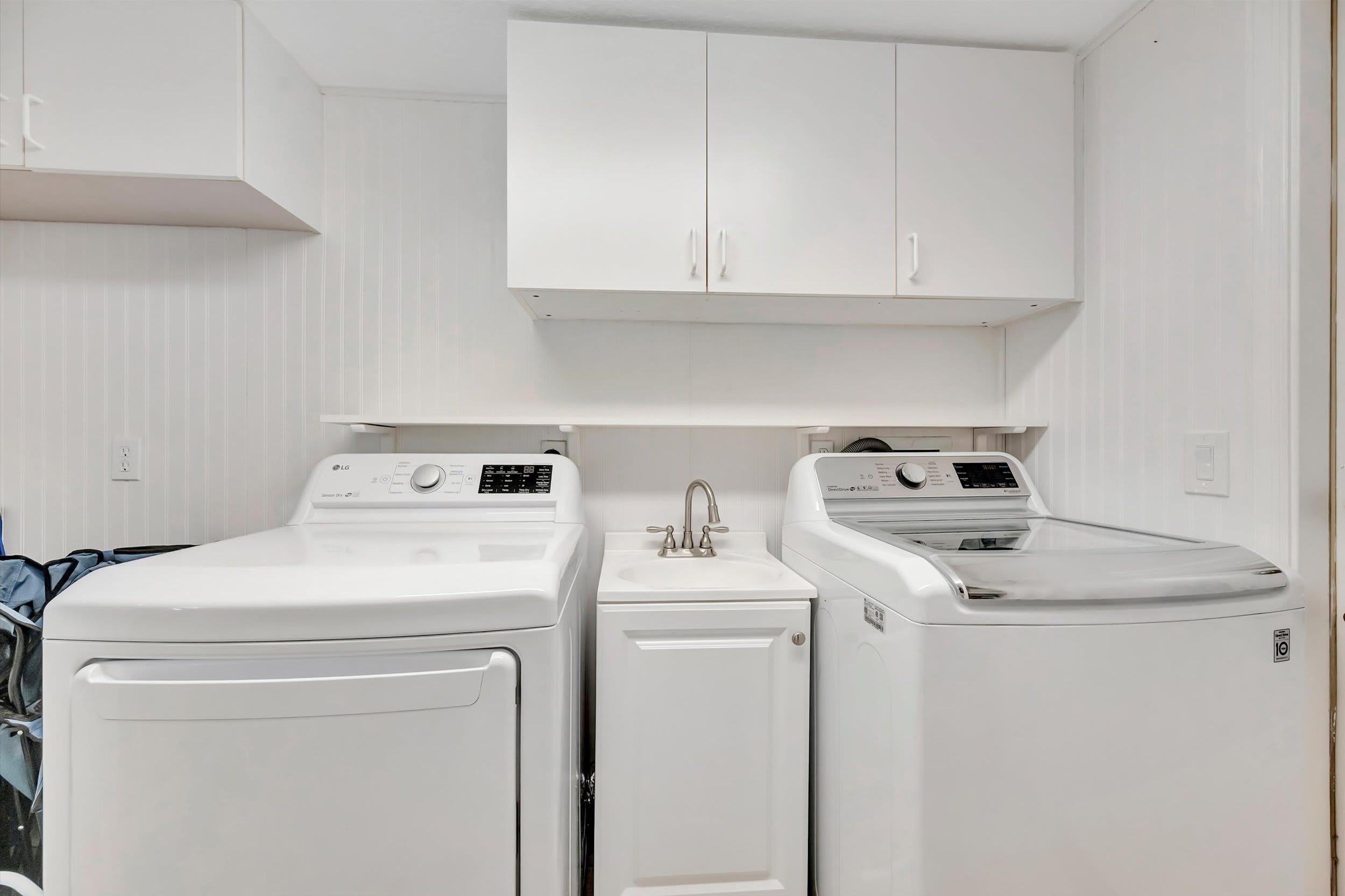 A pristine laundry room awaits you with full-size washer and dryer, utility sink, and ample cabinet storage—making it easy to keep your vacation wardrobe fresh and ready.