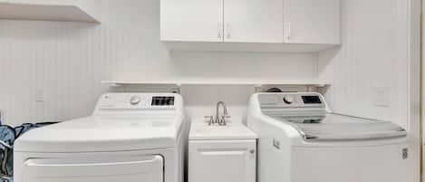 A pristine laundry room awaits you with full-size washer and dryer, utility sink, and ample cabinet storage—making it easy to keep your vacation wardrobe fresh and ready.