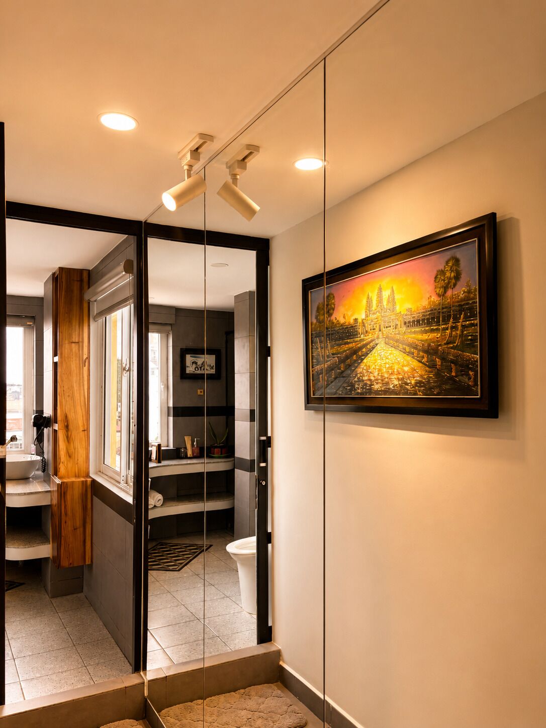A modern bathroom with a glass partition, a sink, and a toilet.