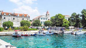 Ein Yachthafen mit vertäuten Booten, eine Kirche mit Glockenturm und Gebäude mit Balkonen.