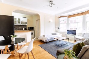 Eine moderne Wohnung mit Essbereich, Küche, Wohnzimmer und einem großen Fenster mit Blick.