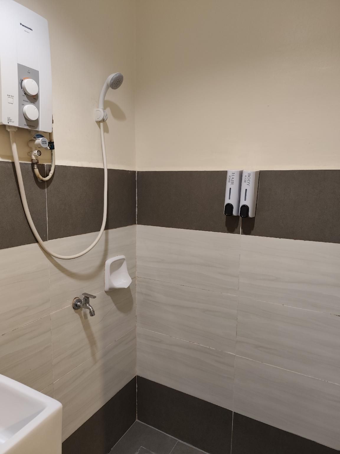 A bathroom with a shower, a toilet, and a sink.