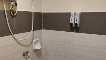 A bathroom with a shower, a toilet, and a sink.