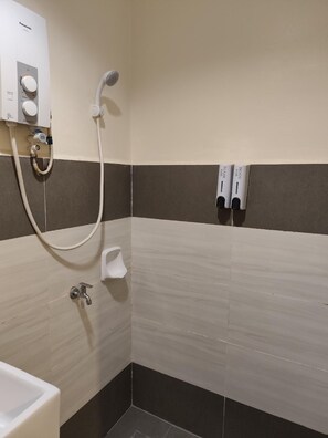 A bathroom with a shower, a toilet, and a sink.