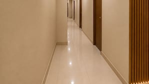 Un pasillo con paneles de madera en la pared, una puerta numerada y un suelo de baldosas.