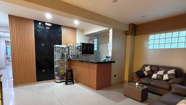 Amplia sala de estar con sofá, mesa de centro y área de cocina con mostrador y armarios.