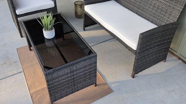 A patio with wicker furniture, a glass table, and a potted plant. - A Trip to the Nursery Capital (McMinnville)