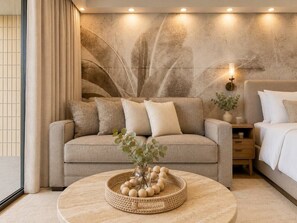 Ein modernes Wohnzimmer mit einer Couch, einem Couchtisch mit Dekoration, einer Wand mit abstrakter Kunst und einem Nachttisch mit Lampe.
