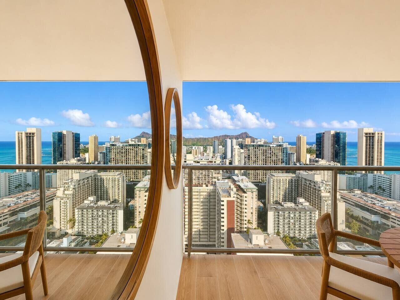 A balcony with a city view, a wooden floor, and a glass railing.