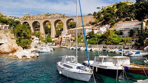 A marina with boats docked, a stone bridge in the background, and buildings along the waterfront. - 1 bedroom nice home in Carry le Rouet (Carry le Rouet)