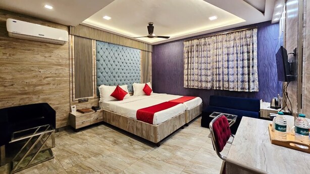 Una habitación de hotel moderna con una cama grande, un escritorio, una silla y un televisor.