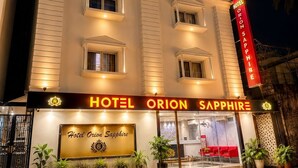 Un hotel de varios pisos con un letrero destacado que dice 'HOTEL ORION SAPPHIRE'.