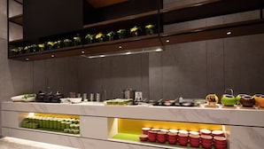 Una cocina moderna con encimera de mármol, estantes con utensilios de cocina y una variedad de utensilios.