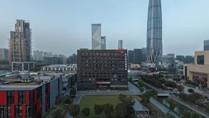 Un paisaje urbano moderno con edificios altos, uno de ellos con una aguja distintiva.