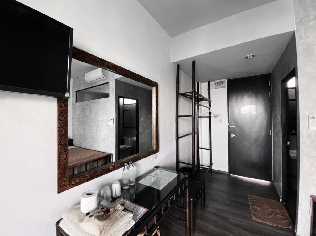 Un baño moderno con un espejo grande, un lavamanos y un inodoro.
