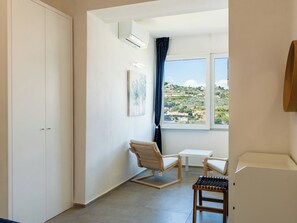 A room with a window, a chair, a small table, and a wardrobe. - Apartment Sirena by Interhome (Sanremo)
