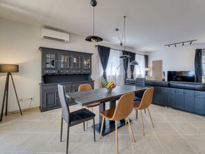 Uma cozinha moderna com uma mesa de jantar, cadeiras e um armário embutido.