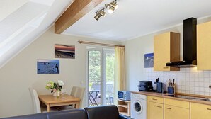 Eine moderne Küche mit Holzausstattung, einem eingebauten Ofen und einem Essbereich mit Tisch und Stühlen.