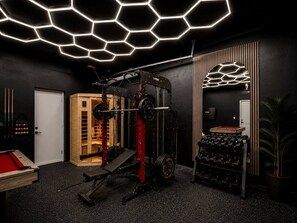 A gym with a squat rack, barbell, and weight plates, a pool table, and a hexagonal light ceiling. - Luxury Retreat • Pool • Spa • Sauna • Sleeps 20+ (Tampa)
