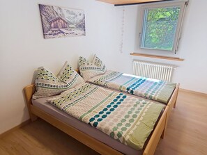 Un lit simple avec un cadre en bois et une couvre-lit matelassée.