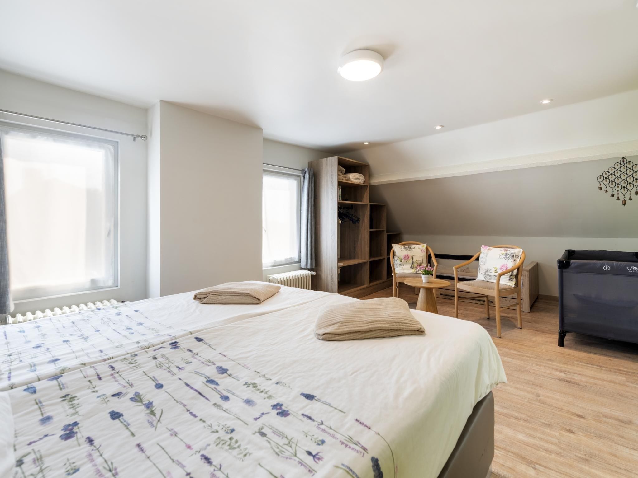 Une chambre à coucher avec un grand lit, une armoire en bois, un bureau et une chaise.