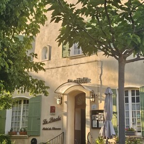 A hotel facade with a sign reading 'Le P'tit Hotel de Charme,' a covered entrance, and a tree in the foreground. - Hotel le Siecle (Mazan)